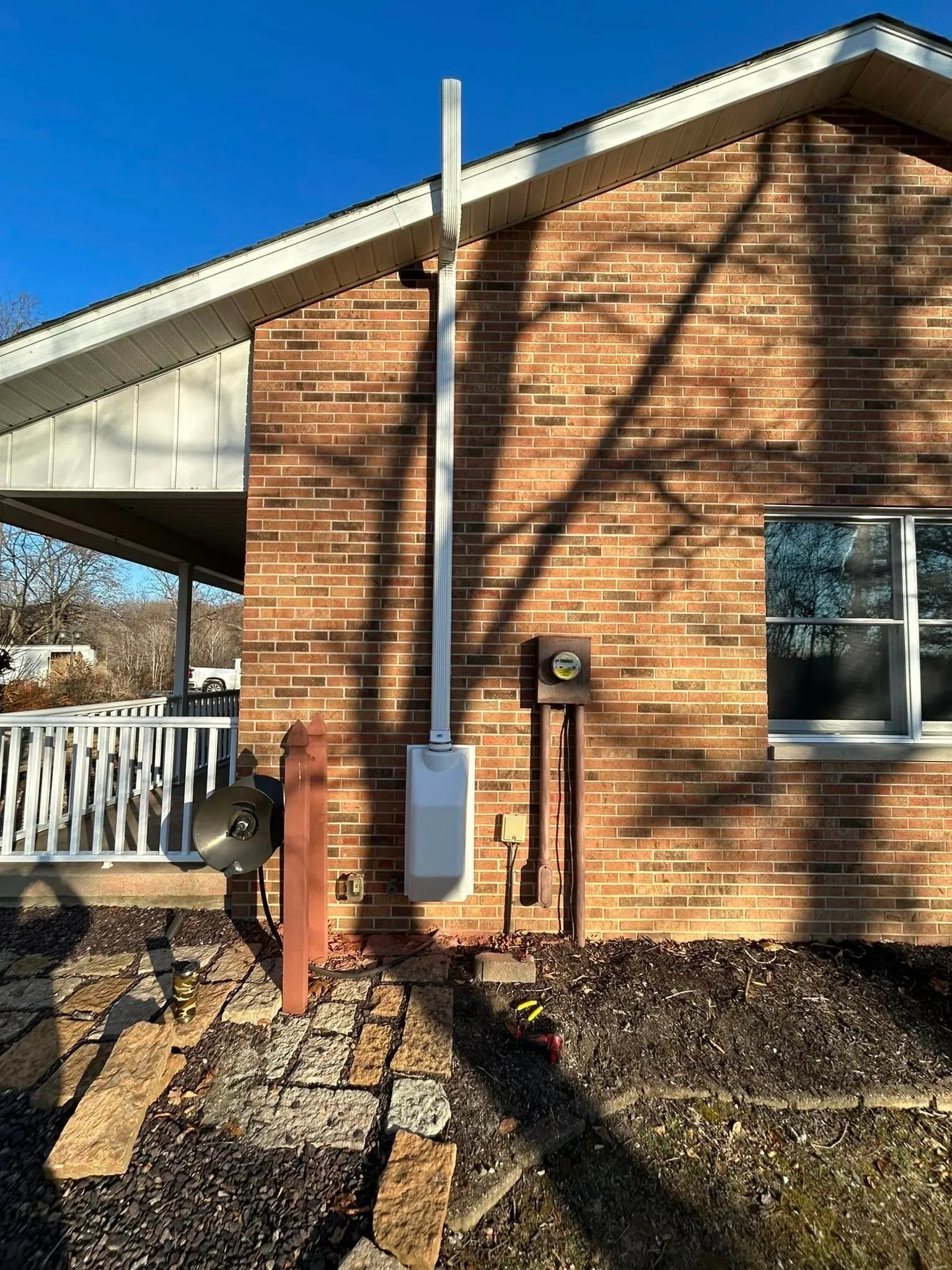 Exterior radon vent pipe on a brick house